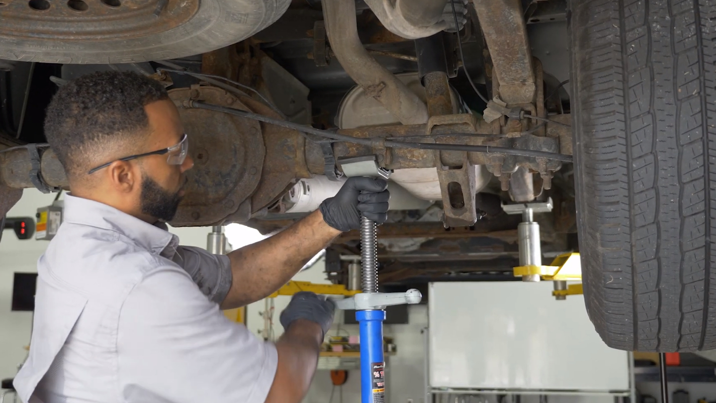 Technician inspecting shocks.
