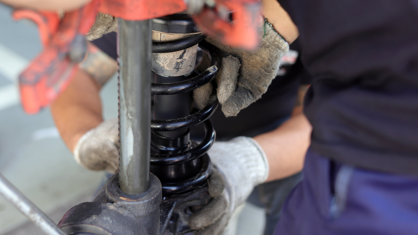 Technician inspecting shocks.