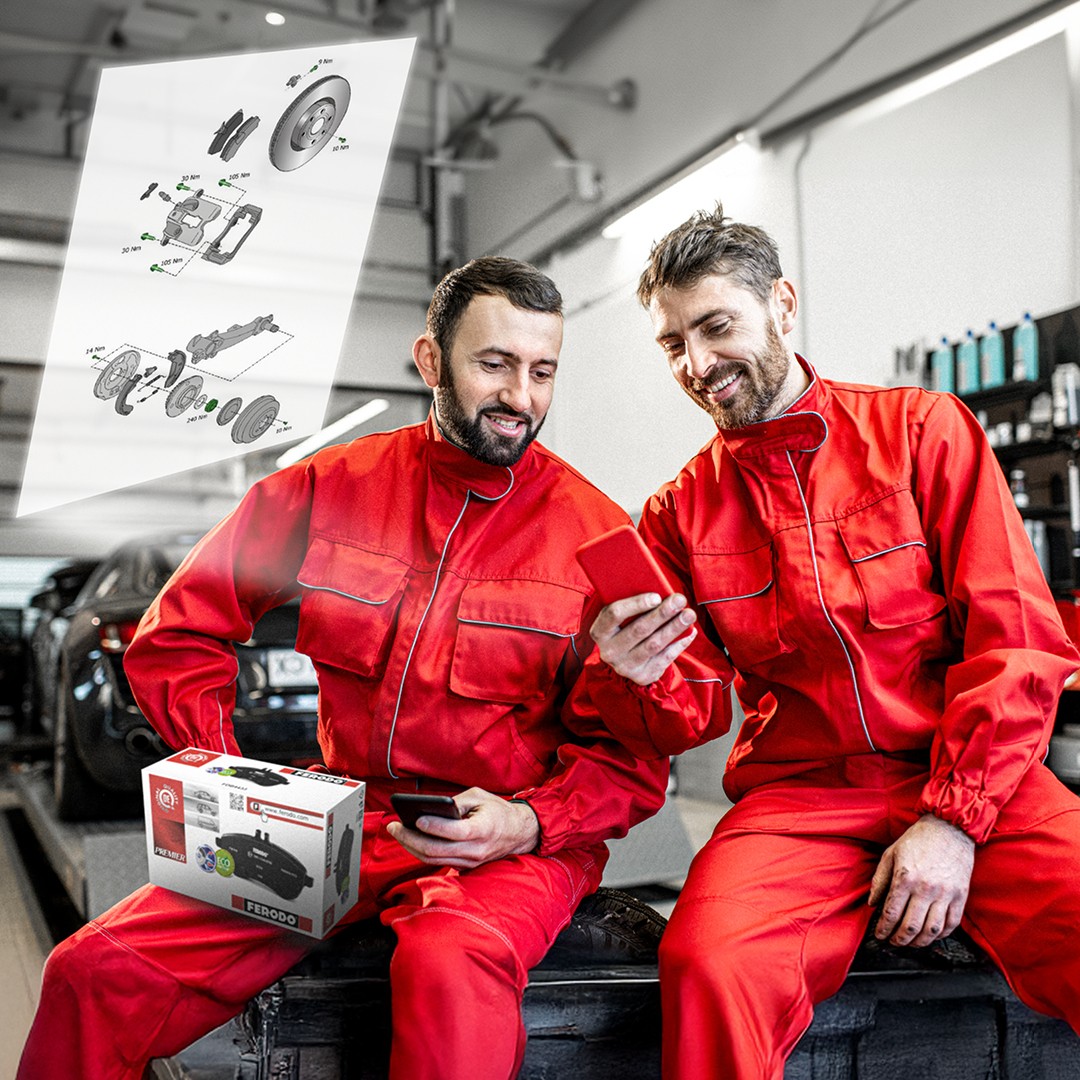 Ferodo technical drawings Zwei Kfz-Mechaniker in einer Werkstatt prüfen detaillierte technische Zeichnungen von Ferodo, die durch Scannen eines Ferodo QR-Codes auf der Produktverpackung aufgerufen werden können