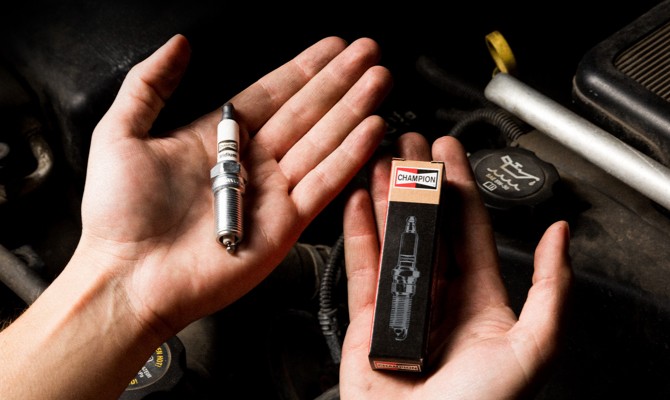 Technician-Holding-Champion-Spark-Plug Mechanic Holding Champion Spark Plug