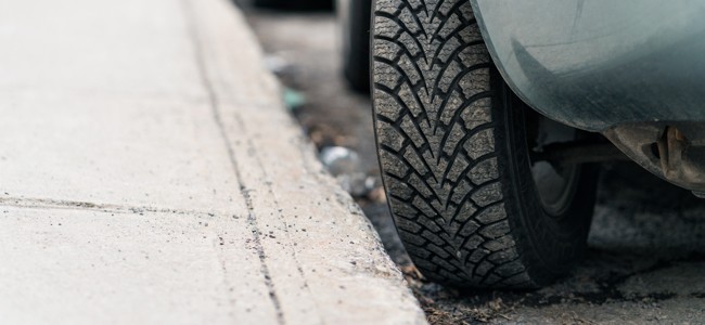 car-tires-turned-into-curb Car tire parked diagonally next to a curb