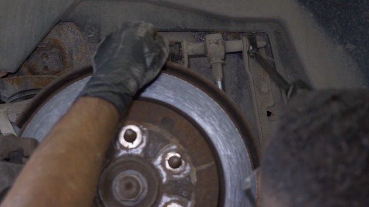 Removing upper mounting nut from vehicle shock Removing upper mounting nut from vehicle shock