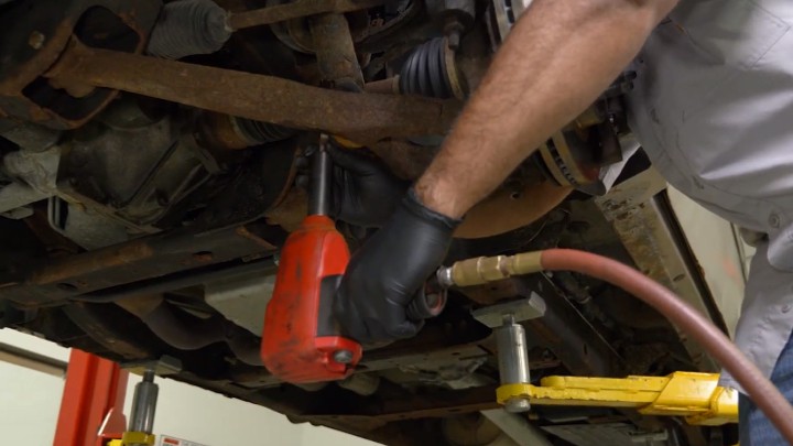 install-struts-chevy-silverado-gmc-sierra-1500-step-2 Technician removing the lower two mounting bolts