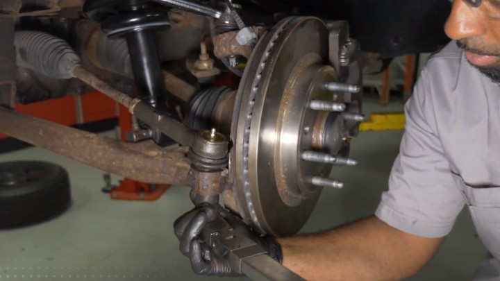 install-struts-chevy-silverado-gmc-sierra-1500-step-8 Technician installing tie rod end to steering knuckle
