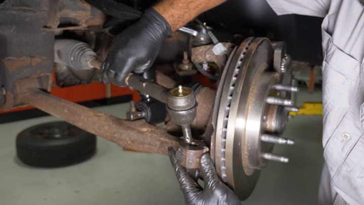 install-struts-chevy-silverado-gmc-sierra-1500-step-7 Technician replacing the outer tie rod