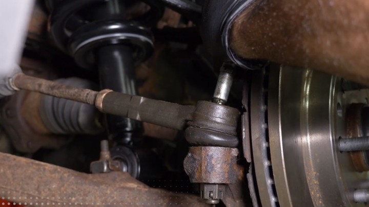 install-struts-chevy-silverado-gmc-sierra-1500-step-10 Technician greasing a new outer tie rod end