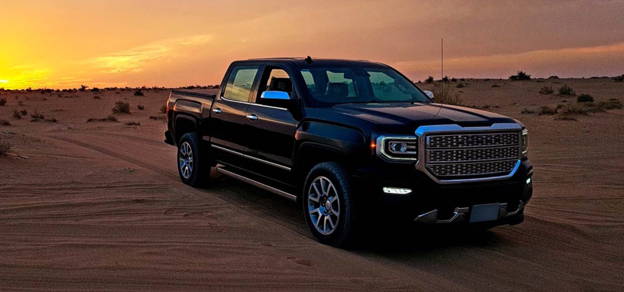 install-struts-chevy-silverado-gmc-sierra-1500-hero Truck driving through the desert with the sun setting behind