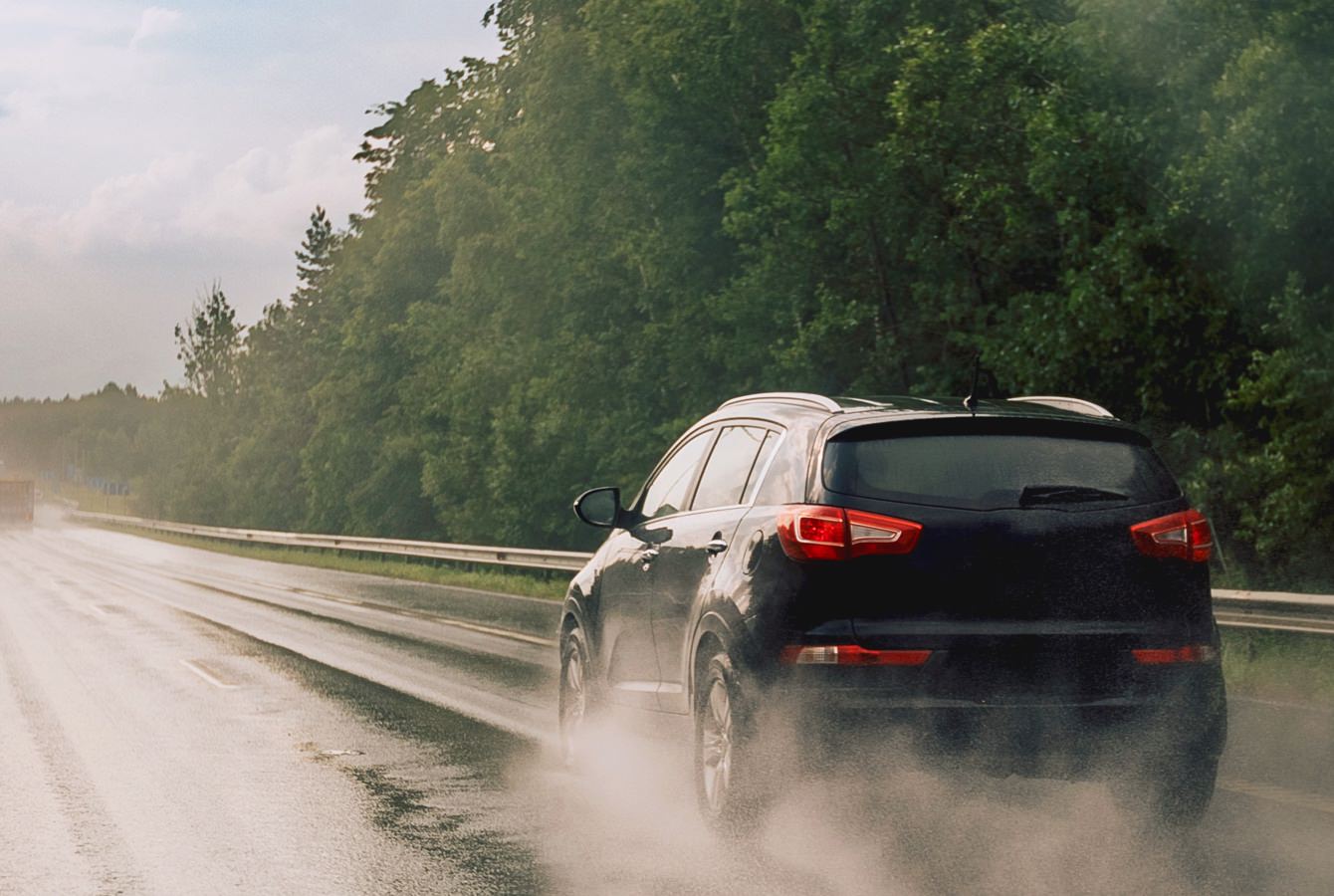Black Suv Driving On Wet Road