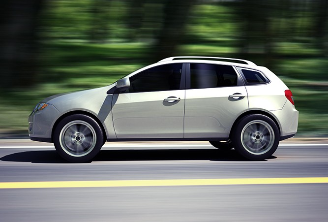 suv-on-the-road Side profile of a sedan driving on the road with the scenery in the background blurred to show that the car is moving.